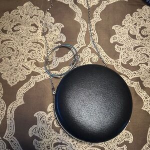 Round black purse can be worn on shoulder or cart by ring as a wristlet